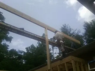 Carpenter setting a ridge beam over a new addition frame — Ice Dam Removal by Roofing Brothers in Beryl