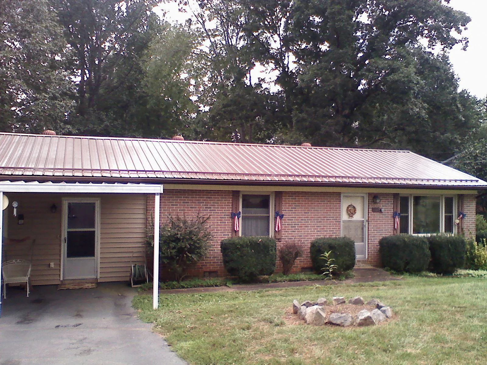 Bronze metal roof and carport on a brick ranch home — Roof Repair work by our crew in Beryl